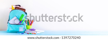 Concept back to school. Full turquoise School Backpack with stationery on table. Banner. Royalty-Free Stock Photo #1397270240