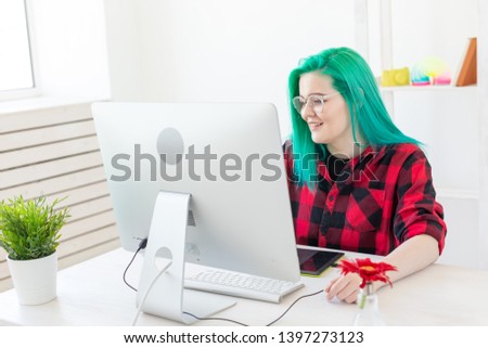 Business, designer and animator concept - young woman illustrator or artist with green hair draws on the graphic tablet