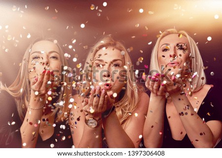 Group of friends partying in a nightclub and toasting drinks