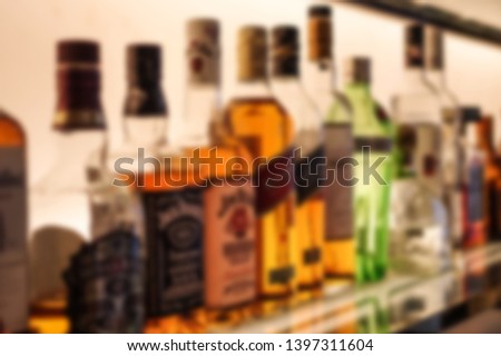 Blurred wine bottles at bar counter defocus background