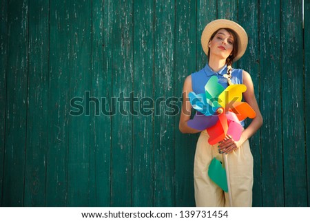 Young happy funny (vintage) dressed woman with colorful weather vane,looking like flower  Picture ideal for illustating woman magazines.