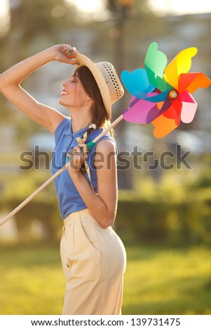 Young happy funny (vintage) dressed woman with colorful weather vane,looking like flower  Picture ideal for illustating woman magazines.