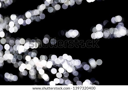 Unfocused abstract white bokeh on black background. defocused and blurred many round light.