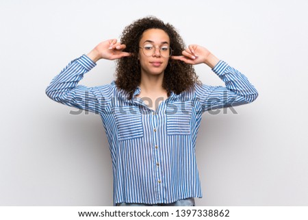 Dominican woman with striped shirt covering both ears with hands