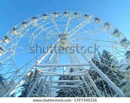Big city ferris wheel on a background of clean blue sky.