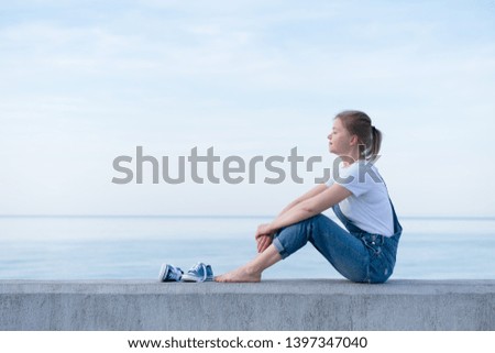 Photo of an adult woman enjoying the sun on the sea coast. Relax.