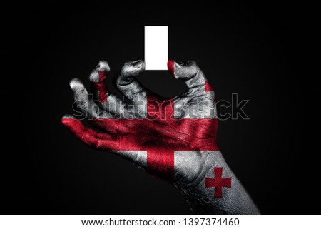 hand with a painted flag Georgia holding a small white sheet with space for an inscription, mock up. Horizontal frame