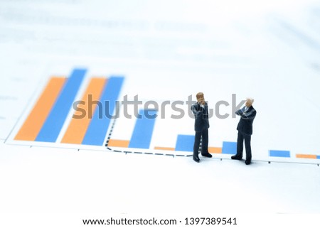 Miniature People : Two investors standing together on a Paper graph chart and discuss on the trend of money ,teamwork, successful, with copy space