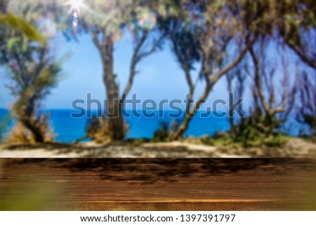 Table background of free space for your decoration. Few trees background and summer sea landscape. 