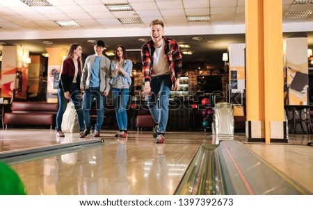 Friends playing bowling in club