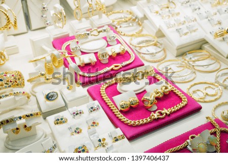 shop window with jewelry in store, gold and silver rings, earrings, chains and necklace