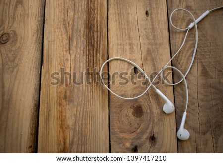 white telephone headphones on a wooden desktop