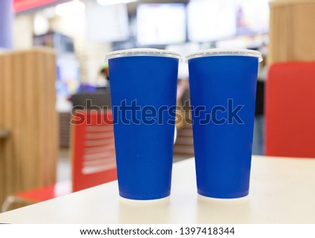 Two blue plastic cups, with a capacity of 0.5 liters on the table in the cafe.
Glasses for lemonade and fresh