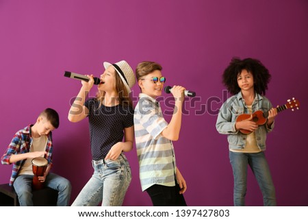 Teenage musicians playing against color background