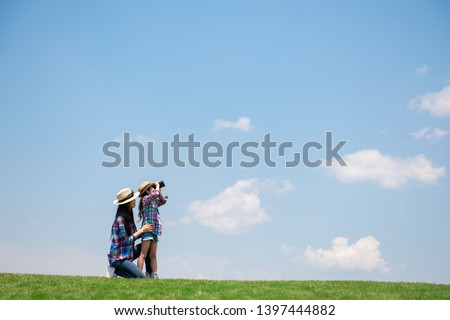 Mother and daughter looking afar with binoculars Royalty-Free Stock Photo #1397444882
