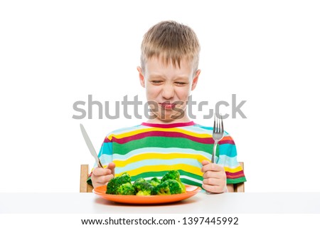 Grimace of a boy who does not like broccoli, portrait on a white background
