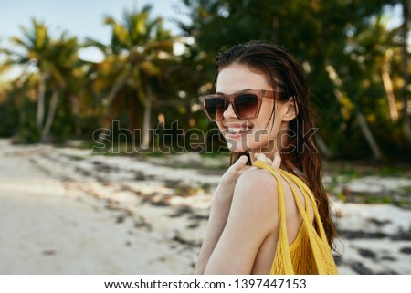 woman in glasses with a yellow bag on the ocean                               