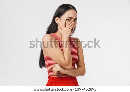 Picture of a beautiful shocked scared young pretty asian woman posing isolated over white wall background.