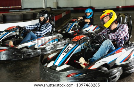 active man and women competing on racing cars at kart circuit Royalty-Free Stock Photo #1397468285