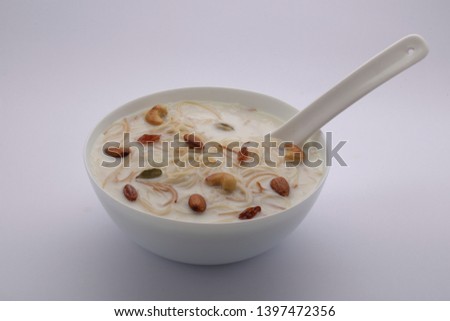 payasam- vermicelli payasam which is garnished with nuts in a white bowl with white spoon which is beautifully arranged on a white background