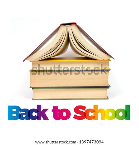 Back to school. Stack of books with roof on white background. Text