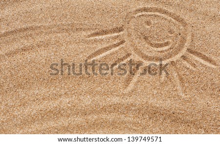 Smiling drawing sun on the sand