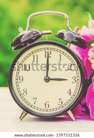 Spring flowers and Alarm Clock. Change the time. nature.