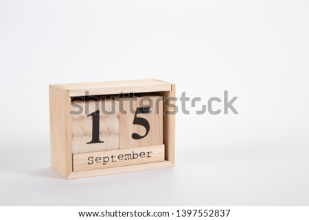 Wooden calendar September 15 on a white background close up