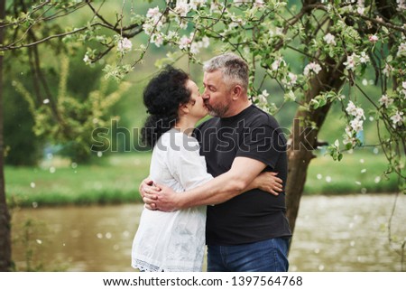 Giving a kiss. Cheerful couple enjoying nice weekend outdoors. Good spring weather.