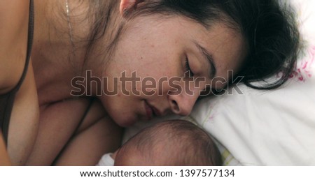 Newborn baby sleeping next to mother in bed, love and care
