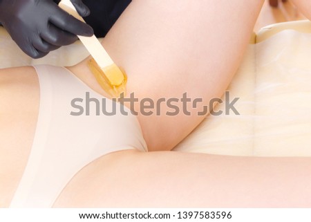 Bikini area depilation. Close-up Of A Beautician shugaring depilation Woman's Leg In Beauty Spa. Body hair removal
