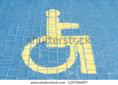 The parking space of cars for disabled people the drawn sign on road tile.