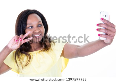 Smiling attractive african woman taking a selfie finger victory V gesture