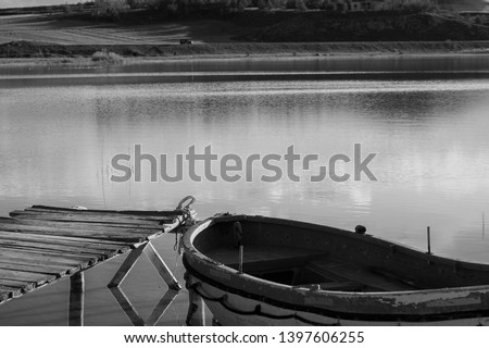 Beautiful Landscape of Boat and Pier. Cockboat on the lake. Wooden pier and Dinghy. Old fishing boat. Sandal on the water. Black and White picture, Zara/Sivas.