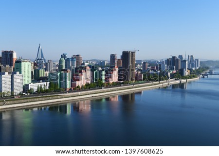 Pyongyang, DPR Korea North Korea and Taedong River in the morning fog. View facing upstream, modern residential complex and Ryugyong Hotel. View from Yanggakdo Hotel  Royalty-Free Stock Photo #1397608625