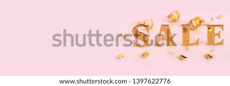 Banner inscription sale in gold letters, golden confetti and serpentine on a pink background.

