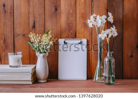 Home interior with decor elements. Mockup clipboard, white daffodils in a vase, interior decoration
