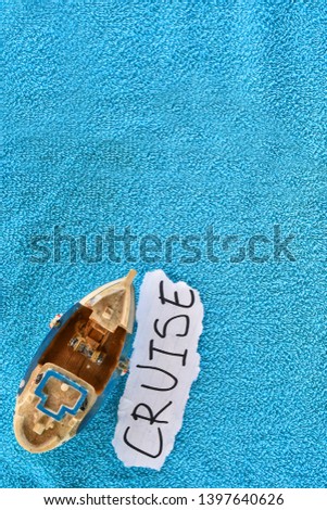 Ship souvenir on a towel with CRUISE note with a copy space - cruise concept