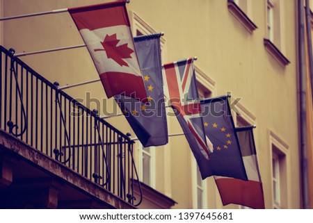 National flags of Canada,European Union,United Kingdom,France on embassy building in Europe.British,Canadian,French and European symbols together on one building balcony
