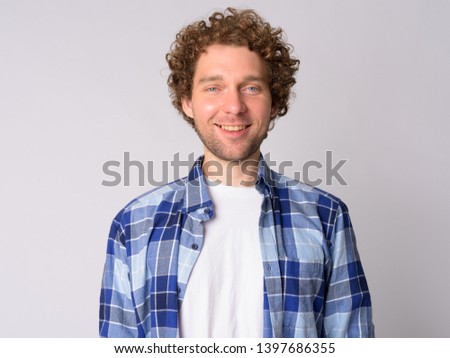Portrait of happy handsome hipster man with curly hair smiling