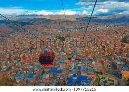 Cityscape of La Paz city with the new public transport system of Cable Cars named Teleferico and the snowcapped Andes mountain peaks in the background, Bolivia.