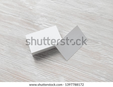 Photo of blank business cards stack on light wooden background. Template for branding identity.
