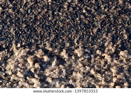snow covered part of the asphalt road in the winter season. Close-up, picture of dirty snow on the surface