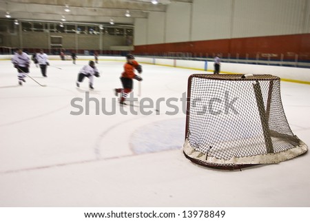 Players chase down opponent as he scores into an empty net