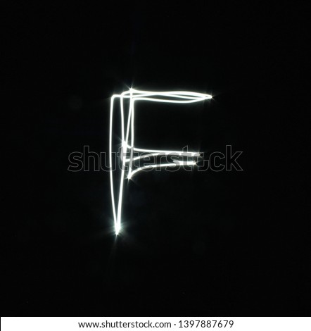F-created by light letters - uppercase character, Pictured by light letters, painted by light, Black background light font,​selective​ focus