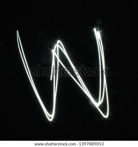 W-created by light letters - uppercase character, Pictured by light letters, painted by light, Black background light font,​selective​ focus
