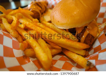 Spicy chicken tender. Spicy fries and cheeseburger sandwich. Junk food picture. Tasty american cuisine. Potatoes and burger on serving tray. Colorful image of delicious meal. California fried lunch. 