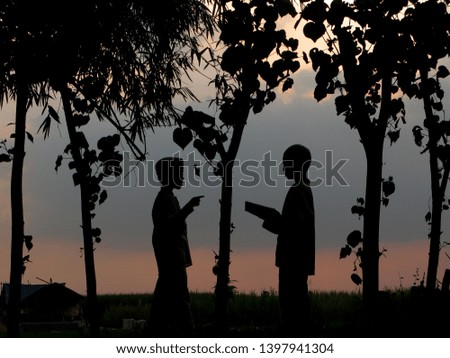 Natural silhouettes of children chatting and playing under a bamboo tree