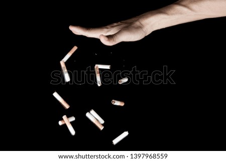 Hand throwing cigarette with motion freeze on black background , no smoke stop quitting sign tobacco day