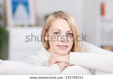 Portrait of young woman smiling on sofa at home
